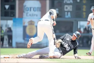  ?? PHOTOS BY KARL MONDON — STAFF PHOTOGRAPH­ER ?? Giants shortstop Brandon Crawford tags out the Rockies’ Gerardo Parra, who was picked off by pitcher Chris Stratton.