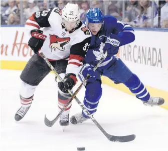  ??  ?? Coyotes defenceman Alex Goligoski and Maple Leafs centre Zach Hyman battle for the puck along the boards during the second period in Toronto on Monday.