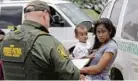  ?? DAVID J. PHILLIP/ASSOCIATED PRESS ?? A mother from Honduras holds her 1-year-old Monday while surrenderi­ng to the U.S. Border Patrol after crossing the border in Texas.