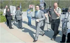  ?? BOB TYMCZYSZYN/STANDARD STAFF ?? David Barrick walks from the parking lot past protestors outside NPCA’s Ball’s Falls offices Wednesday.