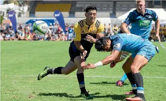  ?? PHOTO: PHOTOSPORT ?? Fullback Nehe Milner-skudder gets a pass away under pressure, during the Hurricanes’ pre-season win over the Blues on Saturday.