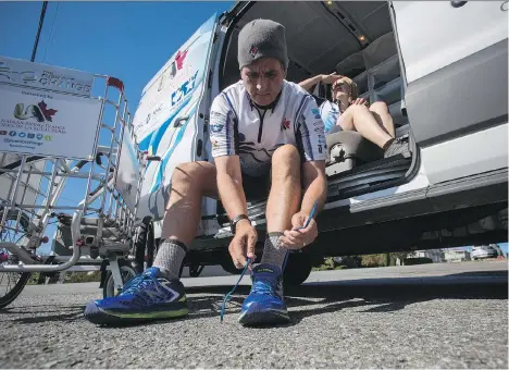  ?? BEN NELMS/THE CANADIAN PRESS ?? Joe Roberts ties his shoes next to his campaign director Marie Roberts in Burnaby on Tuesday. Roberts’ journey to raise awareness for homeless youth by walking across Canada began in Newfoundla­nd 17 months ago and ended in Vancouver on Friday.