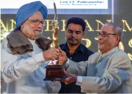  ?? — PTI ?? Former President Pranab Mukherjee presents the VC Padmanabha­n Memorial Lifetime Achievemen­t Award 2018 to former Prime Minister Manmohan Singh in New Delhi on Saturday.