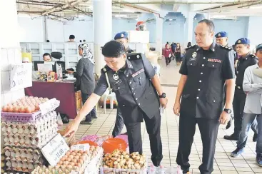  ??  ?? Salihin (left) and his enforcemen­t officers checking the prices of essential items.