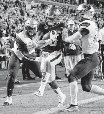  ?? Michael Wyke / Associated Press ?? A&amp;M running back Trayveon Williams pushes his way past two UAB defenders to score a touchdown in the Aggies’ 41-20 victory last week.