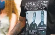  ?? David Zalubowski Associated Press ?? TERRANCE ROBERTS wears a shirt with images of police officers involved in the August stop of Elijah McClain, 23, at a memorial site in Aurora, Colo.