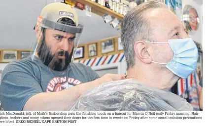  ?? GREG MCNEIL/CAPE BRETON POST ?? Mark Macdonald, left, of Mark’s Barbershop puts the finishing touch on a haircut for Marvin O’neil early Friday morning. Hairstylis­ts, barbers and many others opened their doors for the first time in weeks on Friday after some social isolation precaution­s were lifted.