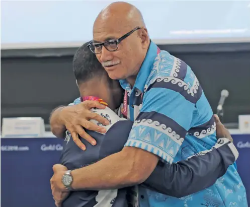  ?? Photo: Anasilini Rtauva ?? President Major General (Ret’d) Jioji Konrote (right) hugsTeam Fiji weightlift­er Manueli Tulo in Gold Coast, Australia on April 3, 2018.