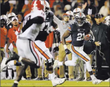  ?? Curtis Compton The Associated Press ?? Auburn running back Kerryon Johnson, right, breaks clear of Georgia defenders for a 55-yard touchdown catch-and-run on Saturday in Auburn, Ala. The 10th-ranked Tigers routed the second-ranked Bulldogs — the No. 1 team in the CFP rankings — 40-17.