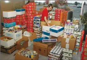  ?? The Sentinel-Record/Richard Rasmussen ?? HOLIDAY FOOD DRIVE: Oaklawn Racing & Gaming employee Justin Stevens loads nonperisha­ble food items into boxes at Oaklawn on Tuesday. The food was collected from patrons and employees during the annual weeklong Yes! We Can! holiday food drive and was...