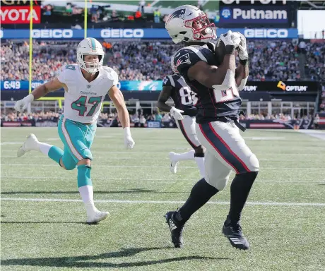  ?? STEVEN SENNE/THE ASSOCIATED PRESS ?? New England Patriots running back James White catches a touchdown pass in the end zone in front of Miami Dolphins linebacker Kiko Alonso Sunday in Foxborough, Mass. He also ran for a score as the Pats scored a 38-7 win over the previously unbeaten Dolphins.