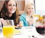  ??  ?? Journalist Laura Mitchell, right, was on a mission to see a grizzly bear while riding on the Rocky Mountainee­r. She enjoys breakfast aboard the train with fellow U.K. journalist Hollie-Rae Brader.