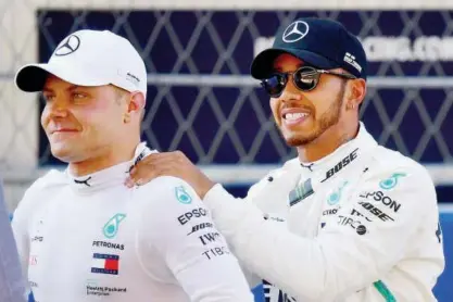  ?? Agence France-presse ?? Pole position winner Mercedes’ Finnish driver Valtteri Bottas (left) and his second-positioned team-mate Lewis Hamilton react after the qualifying session for the Formula One Russian Grand Prix at the Sochi Autodrom circuit in Sochi on Saturday.