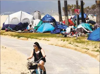  ?? Genaro Molina Los Angeles Times ?? A BICYCLIST rides past homeless tents along the bike path in Venice. Sheriff Alex Villanueva has vowed to clear the boardwalk of homeless encampment­s by July 4, annoying other local officials.
