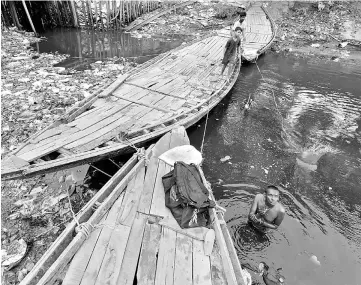  ??  ?? A man offers a prayer as he takes a dip in the polluted waters of Tolly’s Nullah in Kolkata, India. — Reuters photo