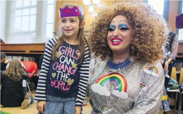  ?? — THE ASSOCIATED PRESS ?? Lil Miss Hot Mess poses with a child after reading to a group of children during Drag Queen Story Hour. ‘Drag queens and children don’t usually get together, which I think is a shame and one of the benefits of a program like this,’ says Lil Miss Hot...