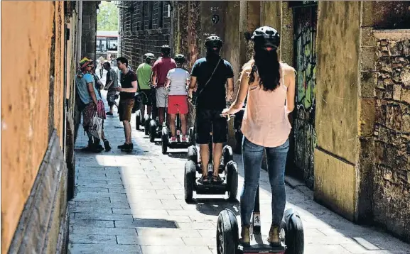  ?? ÀLEX GARCIA ?? Todos en fila. Un grupo de turistas circula en segway por una de las calles estrechas del Barri Gòtic
