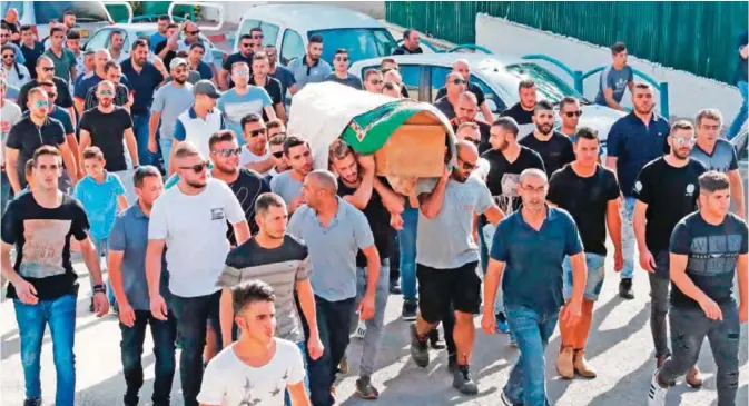  ??  ?? ABU GHOSH, Israel: Mourners carry the coffin of Arab Israeli man, Youssef Ottman, one of three Israeli guards killed in a Palestinia­n shooting attack on a Jewish settlement in the occupied West Bank, during his funeral yesterday. — AFP