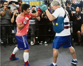  ??  ?? Hard at work: Manny Pacquiao (left) works out with trainer Freddie Roach at a boxing club in Los Angeles on Wednesday. Pacquiao is scheduled to defend his WBA welterweig­ht title against Adrien Broner on Jan 19 in Las Vegas. — AP