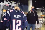  ?? Elise Amendola / Associated Press ?? Football fan Brian Pope browses for Tom Brady jerseys Monday in the pro shop at Gillette Stadium in Foxborough, Mass. Brady is going to the Super Bowl for the 10th time, and Patriots fans are cheering for him — just like before.