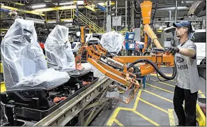  ?? AP/TIMOTHY D. EASLEY ?? Workers assemble Ford trucks Friday at a plant in Louisville, Ky. U.S. businesses reportedly added more jobs in October than expected.