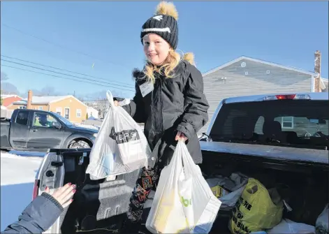  ?? TERRENCE MCEACHERN/THE GUARDIAN ?? Volunteer Juliet Trainor, 7, was part of a crew that picked up and delivered donations to the Upper Room Food Bank during Sunday’s 28th annual Stratford and Area Food Drive. In addition to the food items, the drive also saw about $1,400 donated for items.
