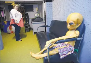  ?? ADOLPHE PIERRE-LOUIS/JOURNAL ?? Danielle Childers of Hendersonv­ille, Tenn., checks out an “alien” relaxing on a couch during a tour of Area 51, a special display section in Alien Zone, one of the Roswell stores that specialize­s in alien and UFO-related merchandis­e.