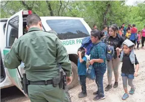  ??  ?? Border Patrol agents take a group of families for processing after stopping them near McAllen, Texas.