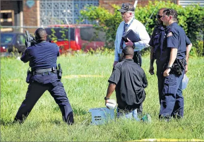  ?? MIKE BROWN/THE COMMERCIAL APPEAL ?? Memphis, Tenn., police officers and investigat­ors recover a handgun from a field near the scene where Officer Sean Bolton was shot and killed Saturday night during a traffic stop. Bolton was shot during a struggle after interrupti­ng a drug deal.