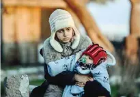  ??  ?? CANAKKALE: A mother and her child wait after being caught by Turkish gendarme at kucukkuyu district in Canakkale. The European Commission said Greece could face border controls with the rest of the EU’s passport-free Schengen zone if it fails to secure...