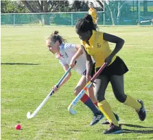  ?? Picture: JON HOUZET ?? DUEL FOR THE BALL: Kate Heny, left, of Port Alfred High School lunges for the ball in the U13A hockey clash against Woodridge Prep last Saturday. PAHS put up a valiant struggle against a stronger team, losing 0-6