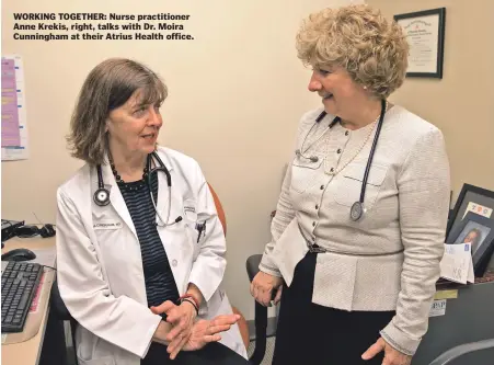  ?? STAFF PHOTO BY MARK GARFINKEL ?? WORKING TOGETHER: Nurse practition­er Anne Krekis, right, talks with Dr. Moira Cunningham at their Atrius Health office.