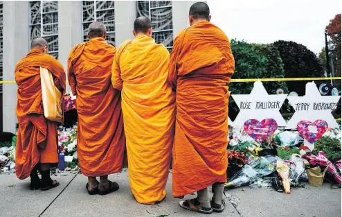  ?? BRENDAN SMIALOWSKI / AFP / GETTY IMAGES ?? Buddhists pay their respects at a memorial set up outside Pittsburgh’s Tree of Life synagogue after last week’s shooting there left 11 people dead. The chair of the Canadian Anti-Hate Network says all faiths must condemn hatred.
