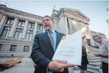  ?? DARRYL DYCK THE CANADIAN PRESS ?? Jay Ritchlin, David Suzuki Foundation director-general for Western Canada, holds a copy of a lawsuit conservati­on groups filed.