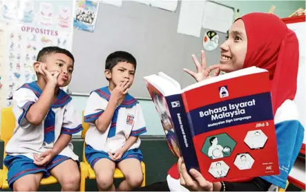  ??  ?? ( Above) Sign language: Teacher Nurul Husna Ibrahim using the latest edition of the Malaysian Sign Language to teach the community’s mother tongue. – File pic
