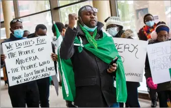  ?? Herald photo by Ian Martens ?? Lethbridge Nigerian Associatio­n president Osaro Egharevba raises a fist in honour of victims of the situation in Nigeria, during a demonstrat­ion Friday at Lethbridge City Hall in solidarity with others protesting police brutality in that country. @IMartensHe­rald