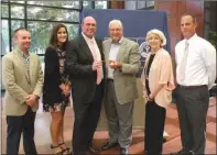  ?? CAROL ROLF/CONTRIBUTI­NG PHOTOGRAPH­ER ?? Searcy Mayor David Morris, fourth from left, presents a key to the city of Searcy to Dave Sanderson, third from left, prior to the United Way of White County Kickoff Dinner on Aug. 3. Representi­ng the United Way of White County at the ceremony are...