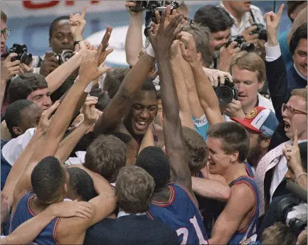  ?? THE ASSOCIATED PRESS FILE ?? Danny Manning, facing camera at center, is mobbed by fans and teammates after leading Kansas over Oklahoma in the 1988NCAA title game.