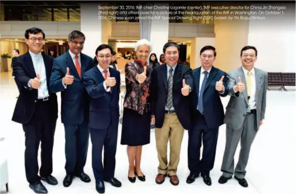  ??  ?? September 30, 2016: IMF chief Christine Lagarde (center), IMF executive director for China Jin Zhongxia (third right) and others pose for a picture at the headquarte­rs of the IMF in Washington. On October 1, 2016, Chinese yuan joined the IMF Special...