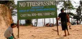  ?? —NESTOR P. BURGOS JR. ?? SLICE OF PARADISE Members of the Ati tribe put up a sign to stake their claim on a piece of ancestral property on the resort island of Boracay in Aklan province.