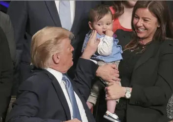  ?? Alex Wong/ Getty Images ?? President Donald Trump touches the cheek of 1- year- old Hudson Nash of Santa Barbara, Calif., as his mother, Jamie Nash, looks on Wednesday during an event in Washington in which Mr. Trump talked about his new organ transplant policies.