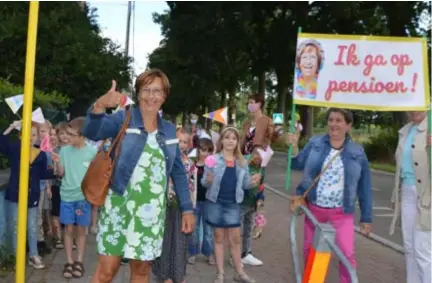  ?? FOTO KMA ?? Juf Annemie net nadat ze uit de cabrio is gestapt aan de bushalte van Mariagaard­e. Rechts enkele collega’s met spandoek.