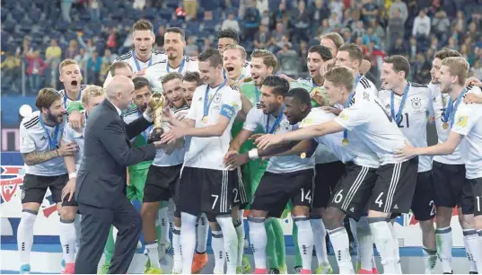  ?? — AFP ?? Fifa president Gianni Infantion hands the trophy to Germany’s Julian Draxler after Germany won the 2017 Confederat­ions Cup final against Chile at the Saint Petersburg Stadium.