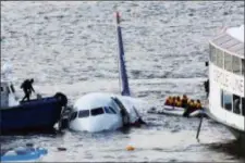  ?? BEBETO MATTHEWS — THE ASSOCIATED PRESS FILE ?? In this file photo, a diver, left, aboard an NYPD vessel prepares to rescue passengers that escaped from the Airbus 320 US Airways aircraft made an emergency landing in the Hudson River in New York.