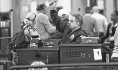  ?? AP PHOTO ?? A Transporta­tion Security Administra­tion officer works at the entrance to Concourse G at Miami Internatio­nal Airport, Friday, in Miami. The airport is closing Terminal G this weekend as the federal government shutdown stretches toward a fourth week because security screeners have been calling in sick at twice the airport’s normal rate.