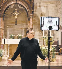  ?? ELSA/GETTY ?? Rev. Brian Needles prepares Saturday ahead of a scheduled livestream of Easter Sunday Mass at Our Lady of Sorrows Catholic Church in South Orange, New Jersey.