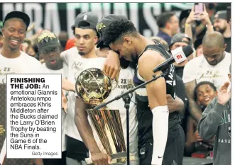  ?? Getty Images ?? FINISHING THE JOB: An emotional Giannis Antetokoun­mpo embraces Khris Middleton after the Bucks claimed the Larry O’Brien Trophy by beating the Suns in Game 6 of the NBA Finals.