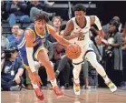  ?? BRANDON DILL/AP ?? Warriors guard Jordan Poole, left, brings the ball up ahead of Grizzlies guard Ja Morant (12) during the first half Tuesday in Memphis, Tenn. Morant strugged against the Warriors, finishing with 20 points and six assists.