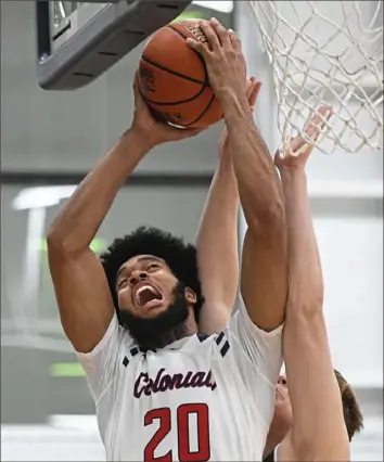  ?? Peter Diana/Post-Gazette ?? Robert Morris’ Charles Bain battles with Bryant’s Patrick Harding Thursday night at North Athletic Complex. The Colonials snapped a two-game losing streak with a 72-59 win.