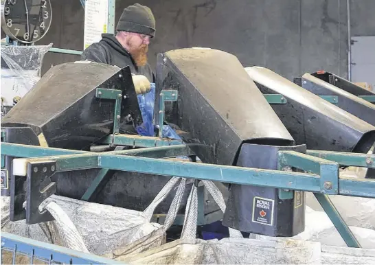  ?? CHELSEY GOULD • SALTWIRE NETWORK ?? Labourer Vincent Chown sorts refundable­s at John Ross & Sons.